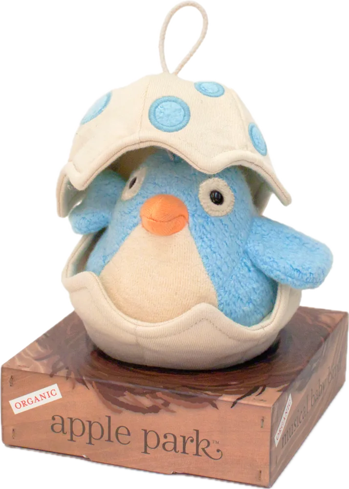 A blue plush bird hatching from an egg, standing on a wood-grain printed box marked Organic and apple park.