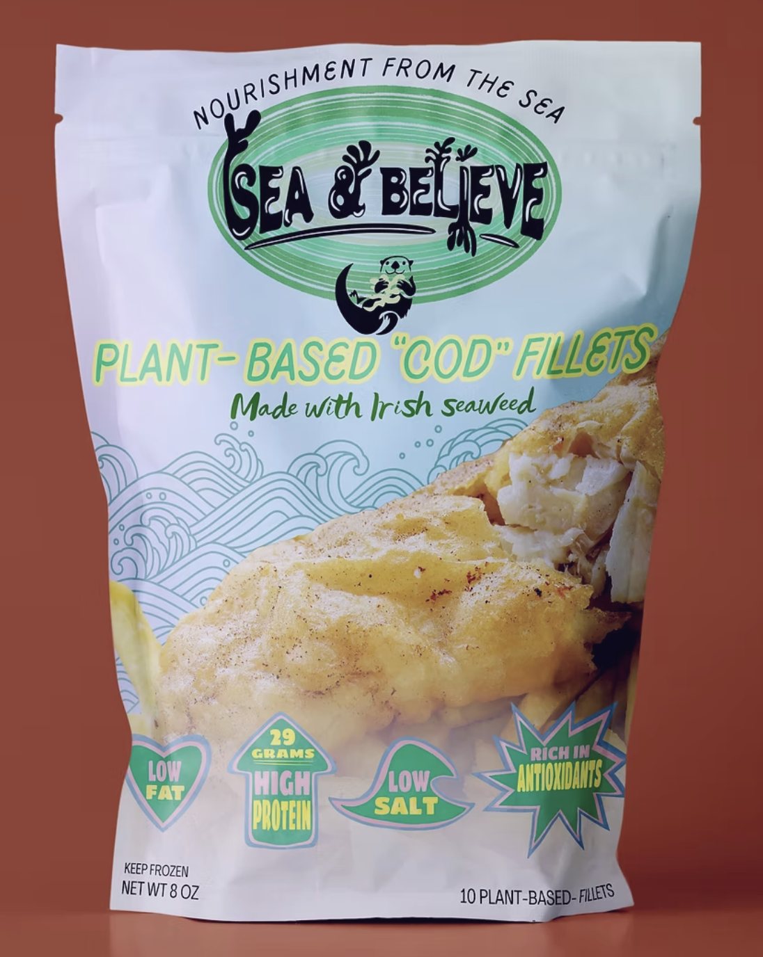 Sea & Believe plant-based cod fillets pouch on a rust ground, showing battered fillets over a wave pattern.
